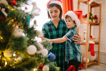 Happy family mom and son on a Christmas winter sunny morning in a decorated Christmas celebration room with a Xmas tree and gifts - 398200017