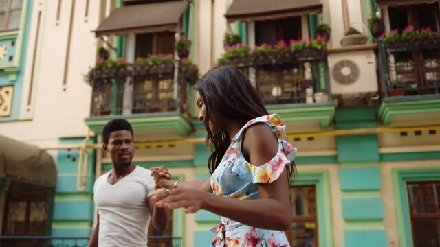 Sexy afro couple performing outdoors. Sexy african girl shaking hips in city