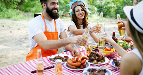 Friends making barbecue and having lunch in the nature