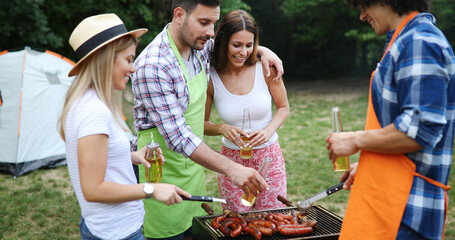Fototapeta premium Friends making barbecue and having lunch in the nature