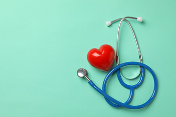 Blue stethoscope and heart on mint background