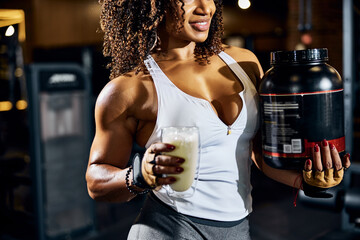 Pleased female athlete with a glass of protein shake