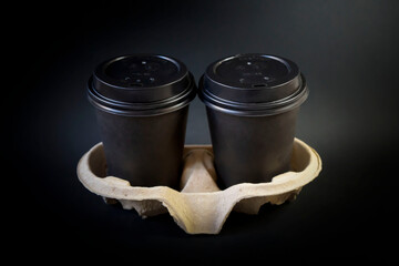 Coffee in disposable glasses on a dark background.