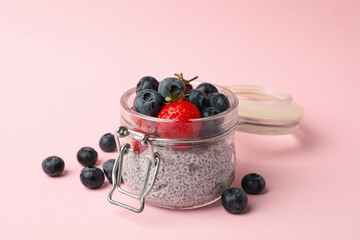 Jar with delicious chia pudding on pink background