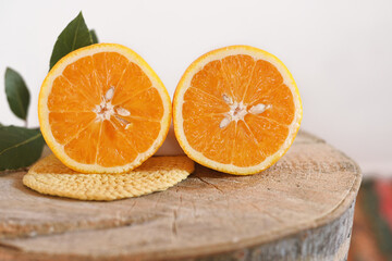Fresh orange and organic cut in two on wood and white background