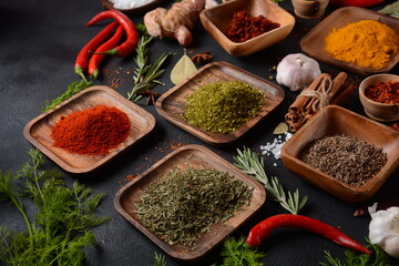 Variety of spices and herbs on kitchen table. Colorful various herbs and spices for cooking on dark background