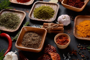Variety of spices and herbs on kitchen table. Colorful various herbs and spices for cooking on dark background