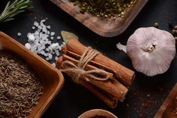 Variety of spices and herbs on kitchen table. Chili pepper powder, oregano,  cinnamon sticks, salt, garlic