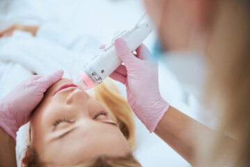 Doctor using hardware cosmetology for treating her patient