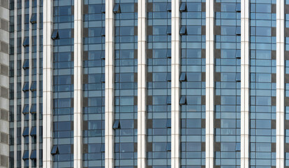 A beautiful background of an glass office building, reflecting clouds in the opened windows