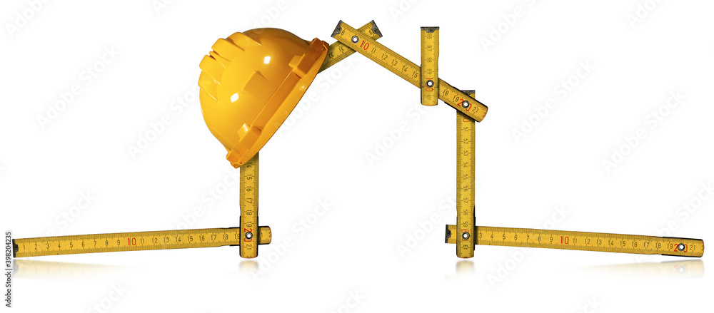 Poster yellow work helmet over a wooden folding ruler in the shape of house, isolated on white background w
