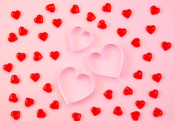 Paper cut hearts on pastel pink background. Composition for Valentine's Day, postcard. Flat lay, top view, copy space.