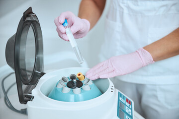 Experienced dermatologist preparing the serum using the medical equipment