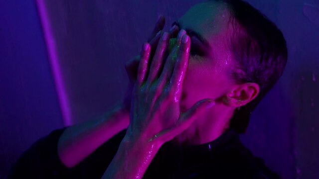 depression and sad feelings of young beautiful woman, she is standing in shower at night, closeup portrait