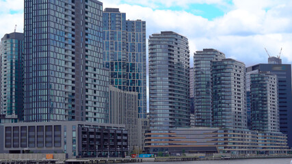 High skyscrapers made of glass and metal. Apartments overlooking the river.
