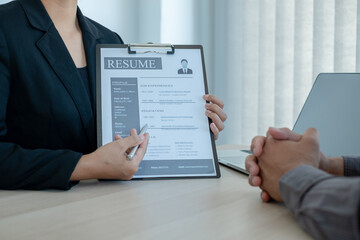 Business people hold a resume and talk to job applicants for job interviews about careers and Her...