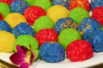 Fototapeta na wymiar colorful sweet rice balls with golden powder, christmas and new year food, asian rice for vegans and vegetarians