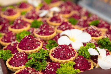 traditional russian beet salad in waffle baskets for new year decorated with sesame seeds, parsley and frangipani flowers, new year and christmas celebration in thailand