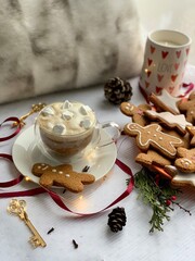 Winter cappuccino coffee in a white cup with man christmas gingerbread cookies. Christmas mood. New Year atmosphere. Cozy home.