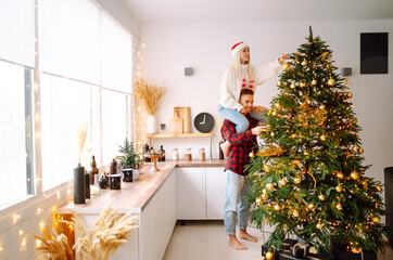 Happy couple decorating christmas tree at home. Smiling Man and Woman together Celebrating Christmas or New Year. Party, family, winter holidays and people concept.