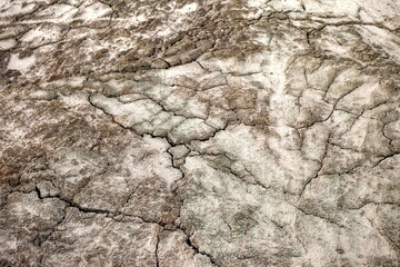 A web of cracks in the gray sand in autumn. Background