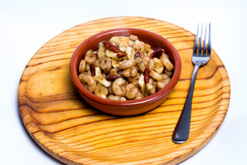 Prawns with garlic and cayenne in a ceramic bowl on a wooden tray