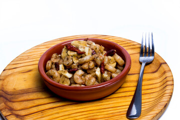 Prawns with garlic and cayenne in a ceramic bowl on a wooden tray