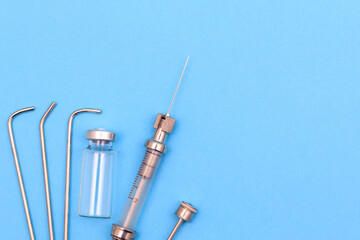 vintage syringe for intrauterine infections and tonsillectomy on blue background. next to it...