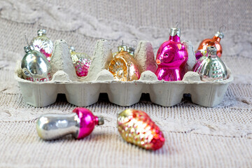 Old soviet decoration in eggbox, glass toy strawberry and pine cone close up on knitted background