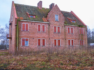 Abandoned brick building with overgrown garden