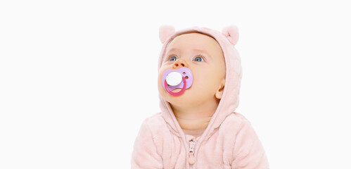 Portrait of little baby in soft pink costume with pacifier over a white background