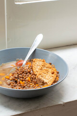A grey/blue plate full of lentil soup