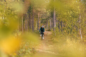 Professional athletic road cyclist ride carbon gravel bike of beautiful autumn forest trail. Cycling exploration adventure or ultra endurance long distance race. Amazing autumn foliage 