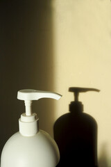 plastic white dispenser of a large volume of a container with cream and a shadow on the wall from it