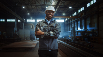 Happy Professional Heavy Industry Engineer/Worker Wearing Uniform, Glasses and Hard Hat in a Steel...