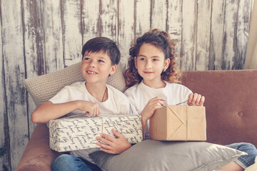 Attractive smiling cute kids brother and sister holding christmas gifts