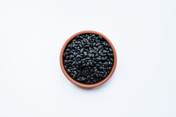 black beans in brown ceramic bowl. bowl of black beans on white background isolated top view photo