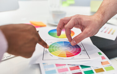 Hands of graphic designers point to color palette