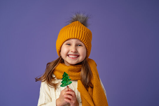 Little Girl In Hat, Holding Lollipop, Stand Happily Smiling On Purple Background