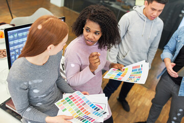 African graphic designer discusses with colleague