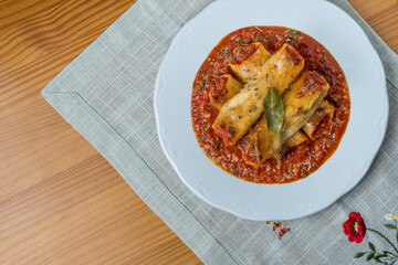 Homemade cannelloni with spices and tomato sauce