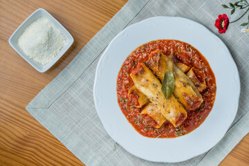 Homemade cannelloni with spices and tomato sauce
