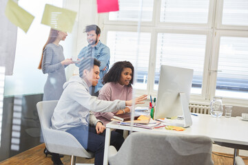 Graphic design team with web designer on computer