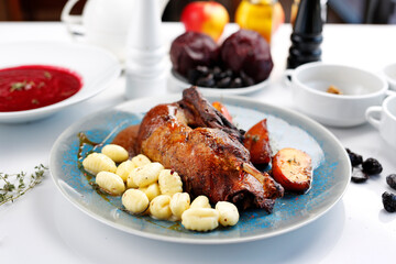 Roast duck with apples in a roast sauce with dumplings.
Appetizing dish served on a plate. culinary photography, food styling.