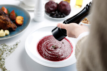 Roasted beetroot soup with raspberry mousse and fresh thyme.
Appetizing dish served on a plate. culinary photography, food styling.