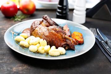 Roast duck with apples in a roast sauce with dumplings.
Appetizing dish served on a plate. culinary photography, food styling.