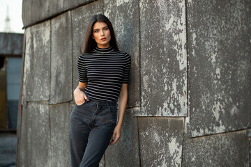 Portrait of a attractive brunette young woman in casual outfit with slim body, stand on roof single, outside.