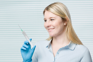 young female doctor or nurse presenting a syringe with a vaccine