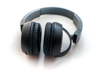 Fototapeta na wymiar Black wireless headphones for audio electronic devices close up on white background