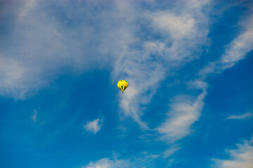 Yellow hot air balloon over blue sky background